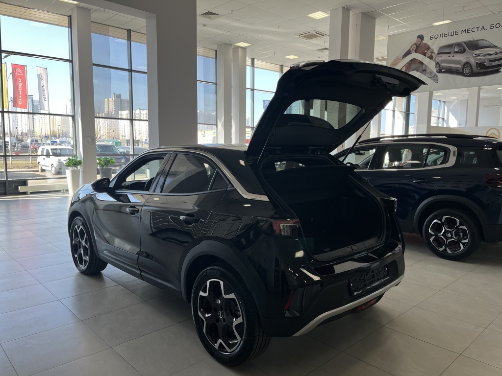 Открытый багажник черного кроссовера Opel Mokka в автосалоне